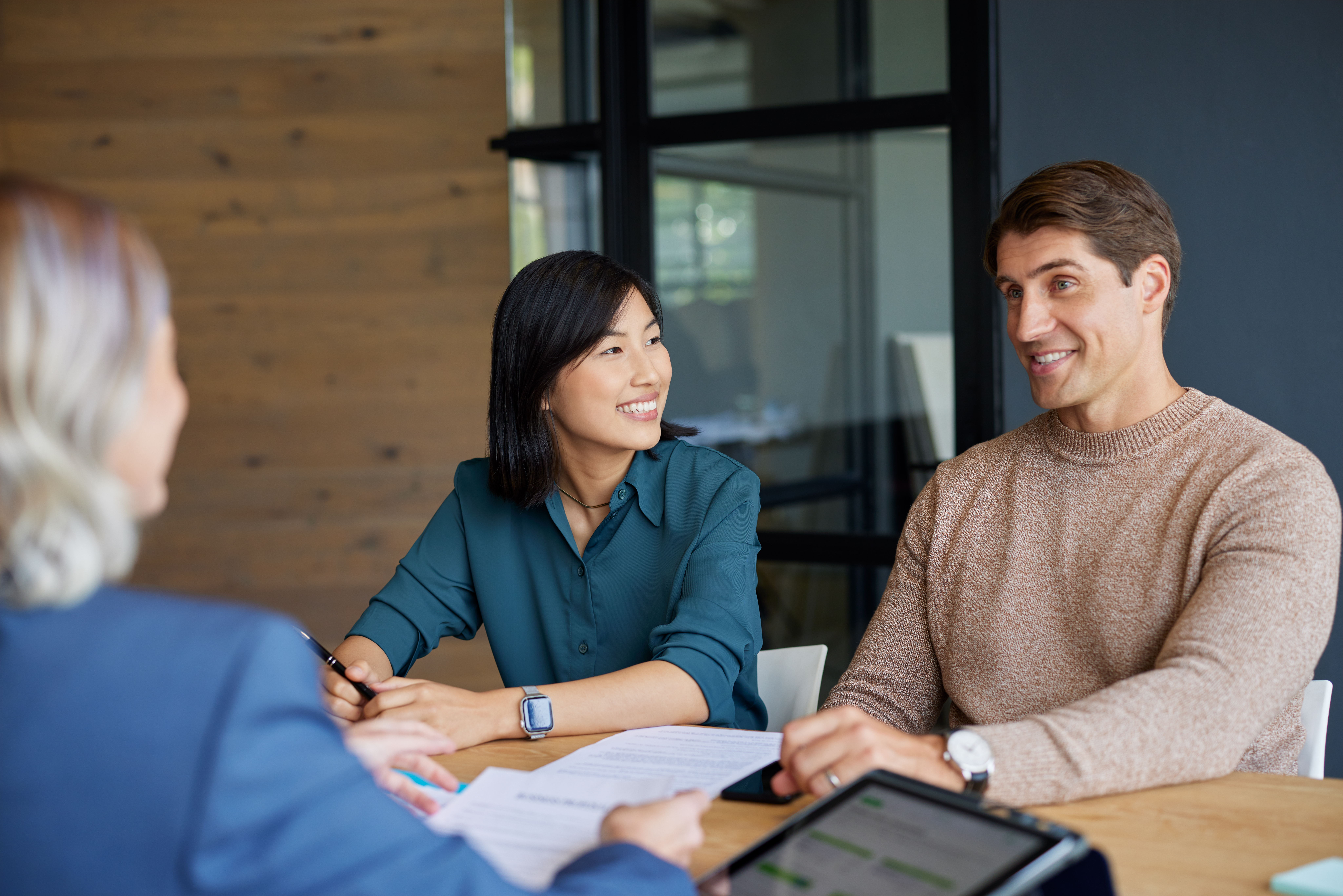 Oficina moderna con equipo colaborando en la gestión empresarial, documentos y ordenador portátil, asesoría profesional en acción