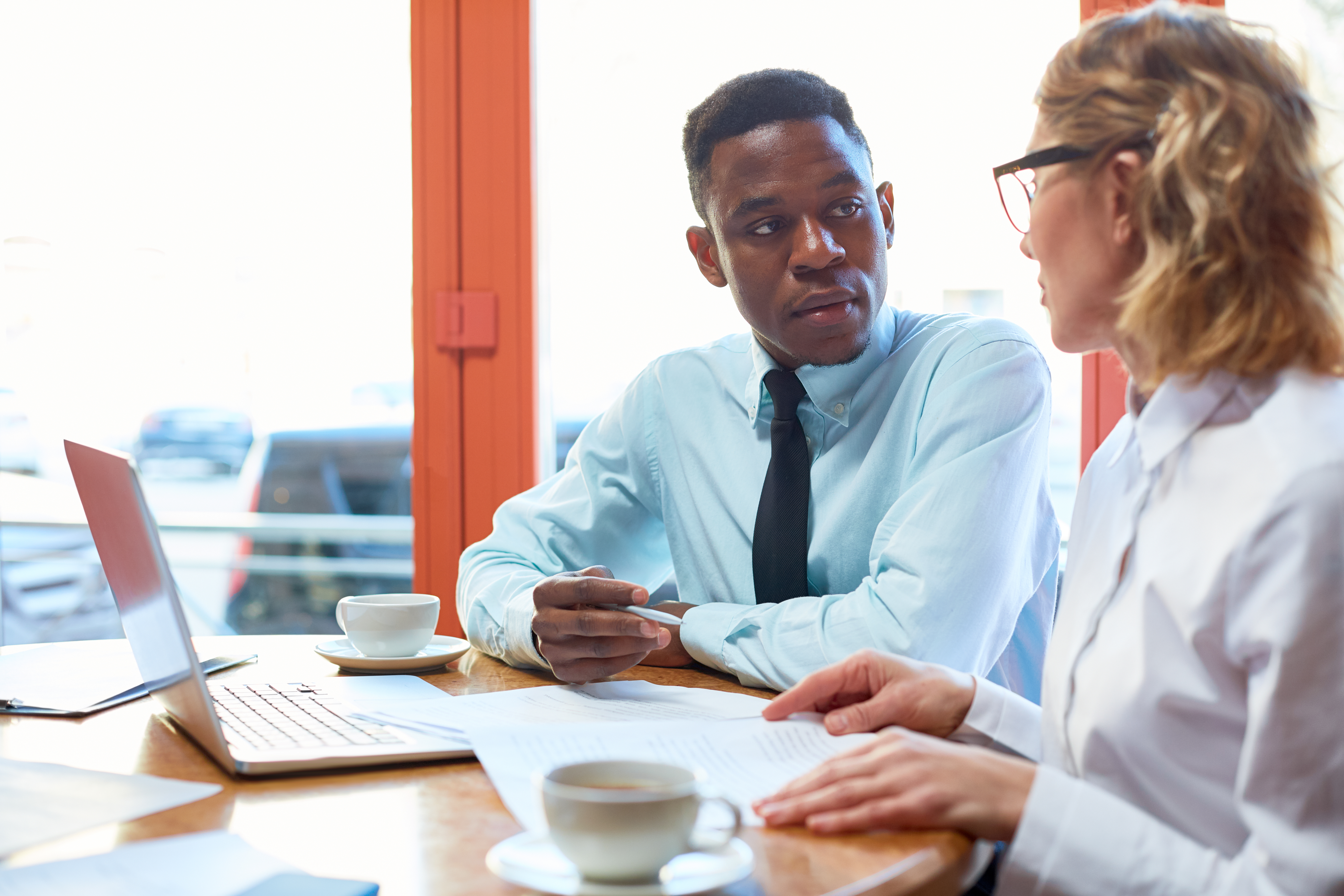 Persona revisando documentos fiscales y calculadora sobre mesa de trabajo, ambiente profesional, concepto de asesoría fiscal experta