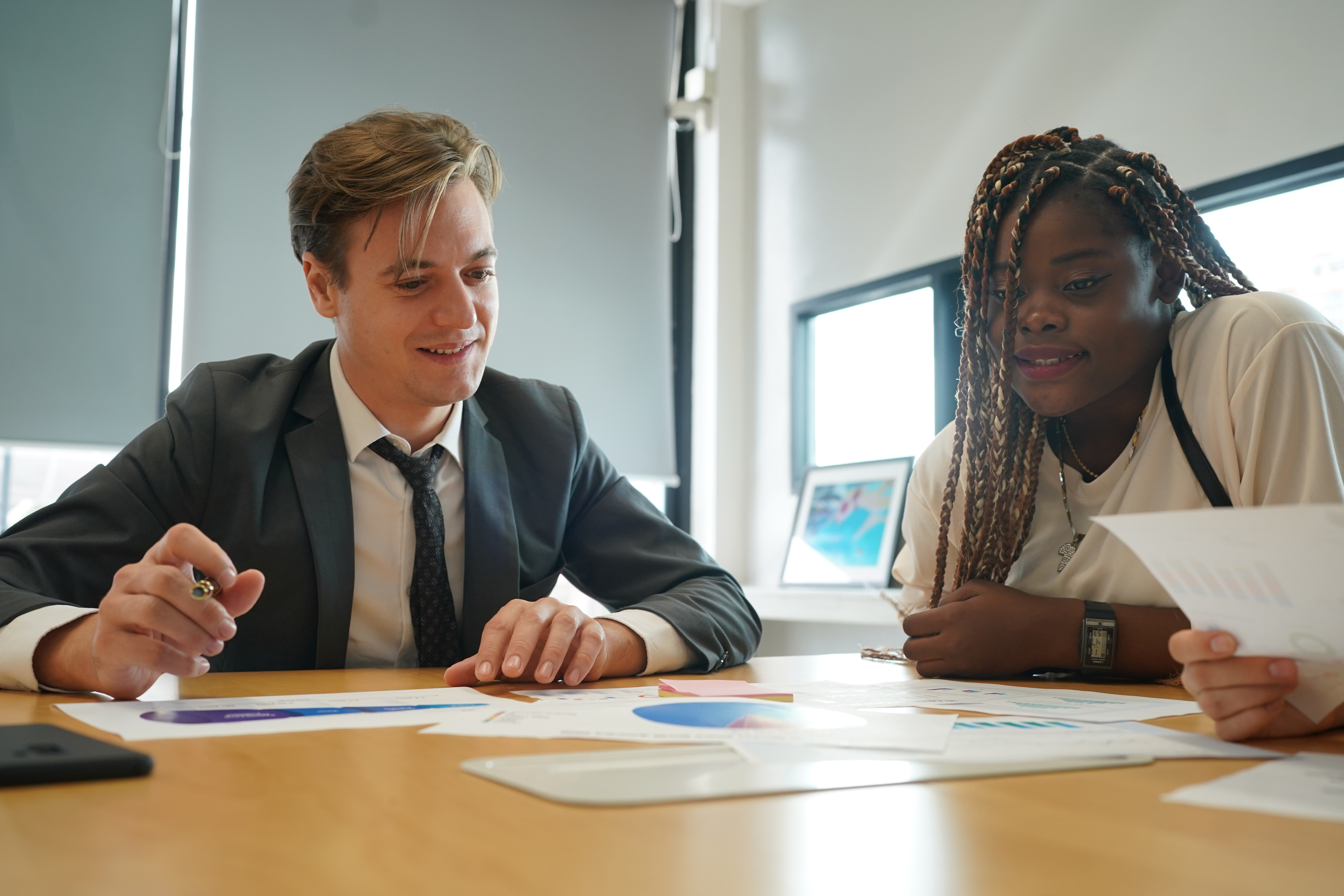 Directivo evaluando gráficos y opciones estratégicas en una sala de reuniones, elección de consultoría adecuada para empresas